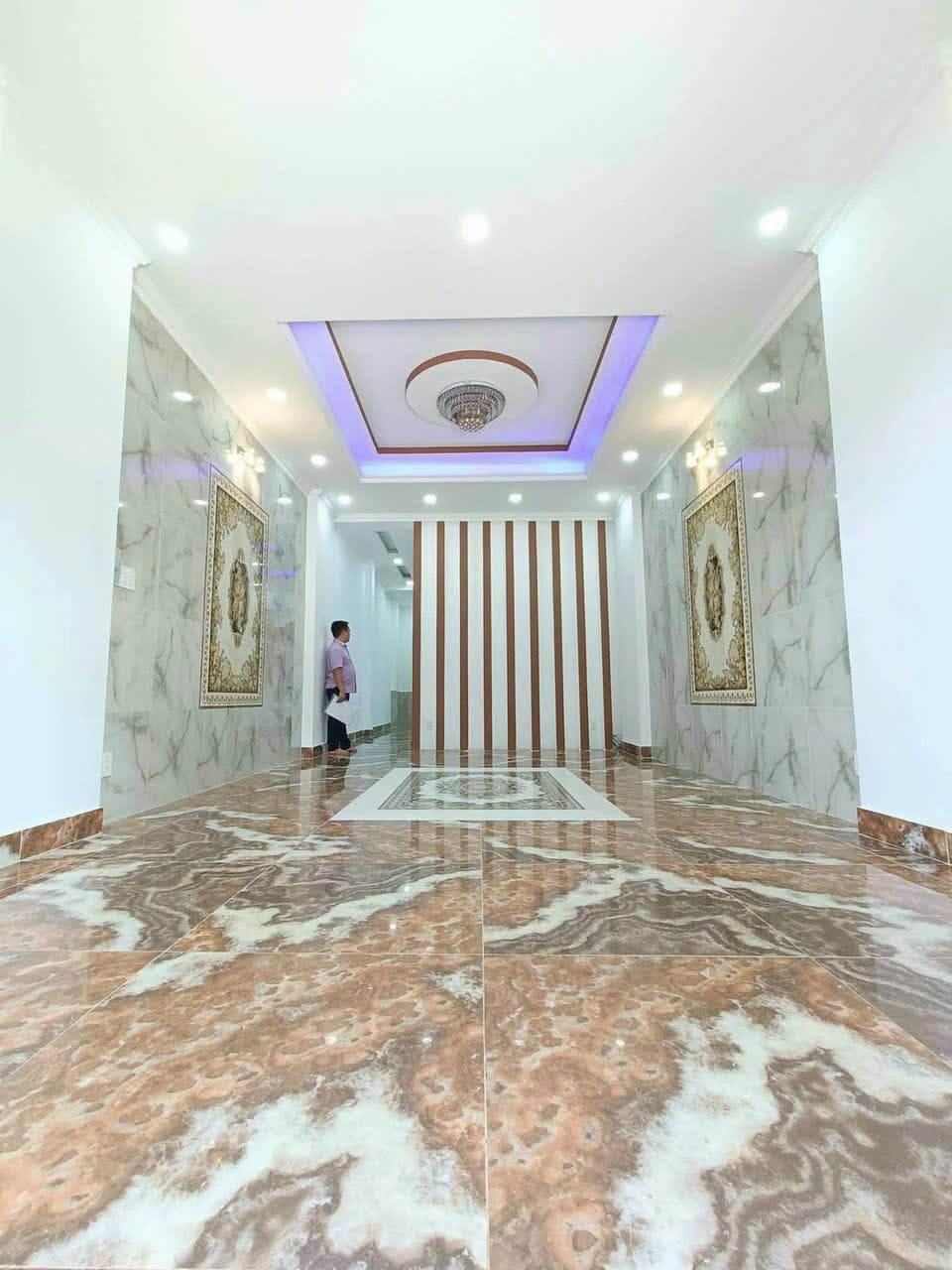 Phòng khách sau khi lát gạch vân đá, ốp tường và làm trần thạch cao