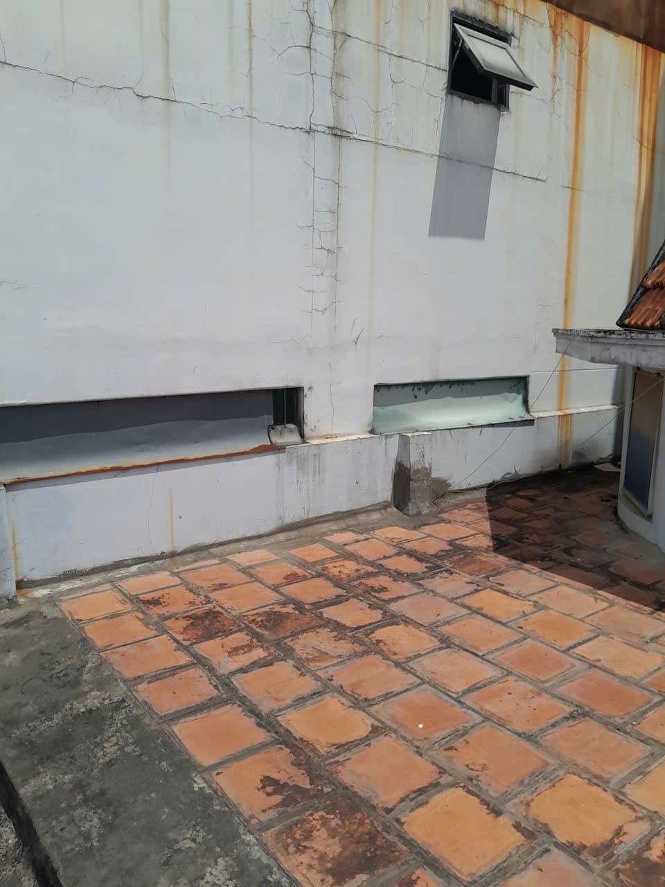 Sân thượng lát gạch tàu cũ, tường ố vàng